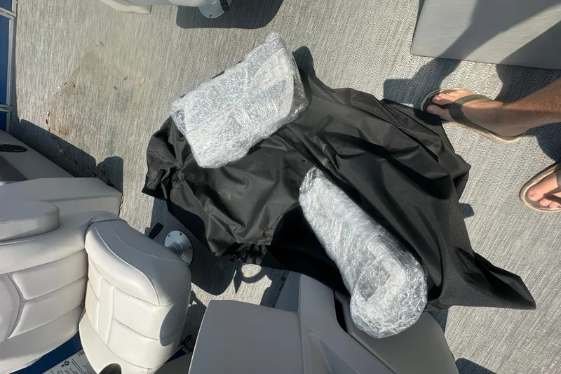 Slide: The Image of 2024 Godfrey SWEETWATER 2286 SB boat interior with wrapped items on deck. - 16