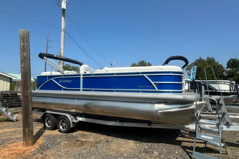Slide: The Image of 2024 Godfrey SWEETWATER 2286 SB pontoon boat on trailer, blue and white design. - 20