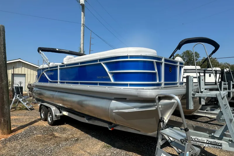 Slide: The Image of 2024 Godfrey SWEETWATER 2286 SB pontoon boat on trailer, blue and silver design. - 21
