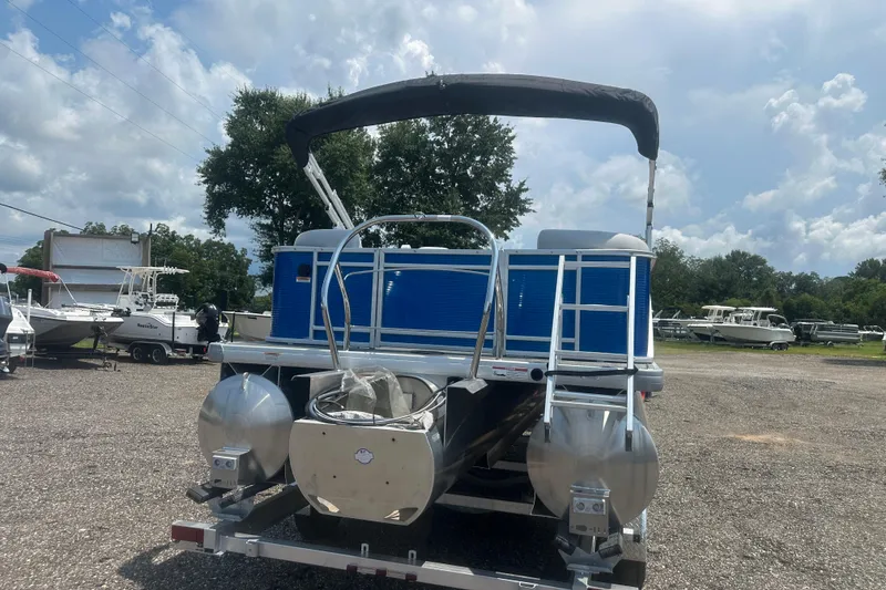 Slide: The Image of 2024 Godfrey SWEETWATER 2286 SB pontoon boat with blue panels and canopy, parked outdoors. - 4