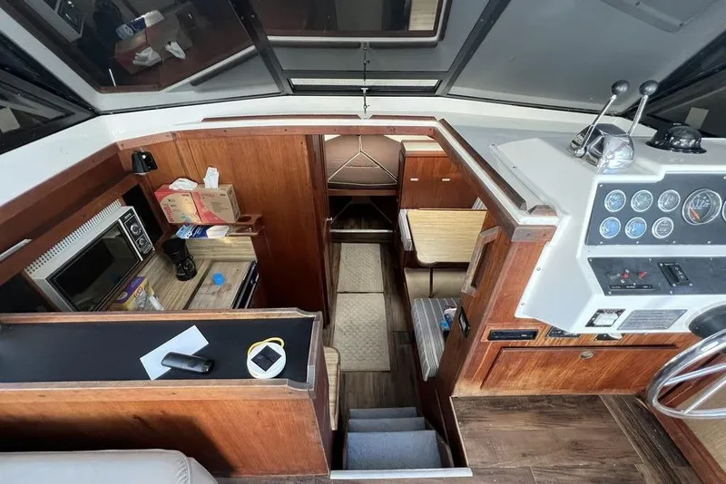Slide: The Image of 1978 Silverton F32 boat interior with wood paneling, kitchenette, and control panel. - 12