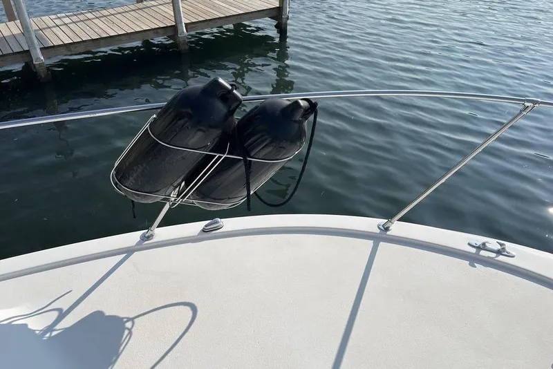 Slide: The Image of 1978 Silverton F32 boat with black fenders on railing, dock in background. - 25