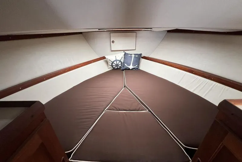 Slide: The Image of 1978 Silverton F32 cabin interior with brown cushions and nautical-themed pillows. - 26