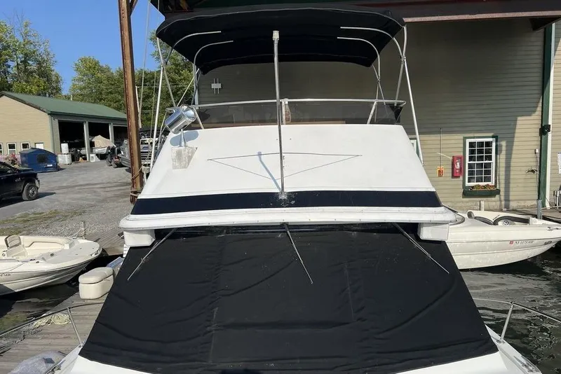 Slide: The Image of 1978 Silverton F32 boat docked, featuring a black canopy and white hull. - 3