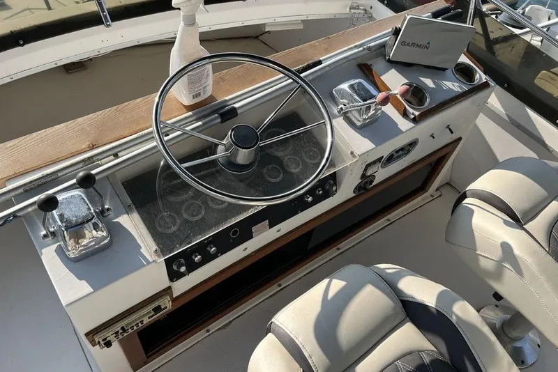 Slide: The Image of 1978 Silverton F32 boat helm with steering wheel, controls, and Garmin device. - 8
