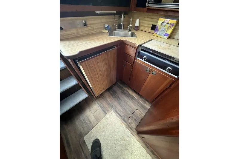 Slide: The Image of 1978 Silverton F32 boat kitchen with wood cabinets, sink, and stove. - 15