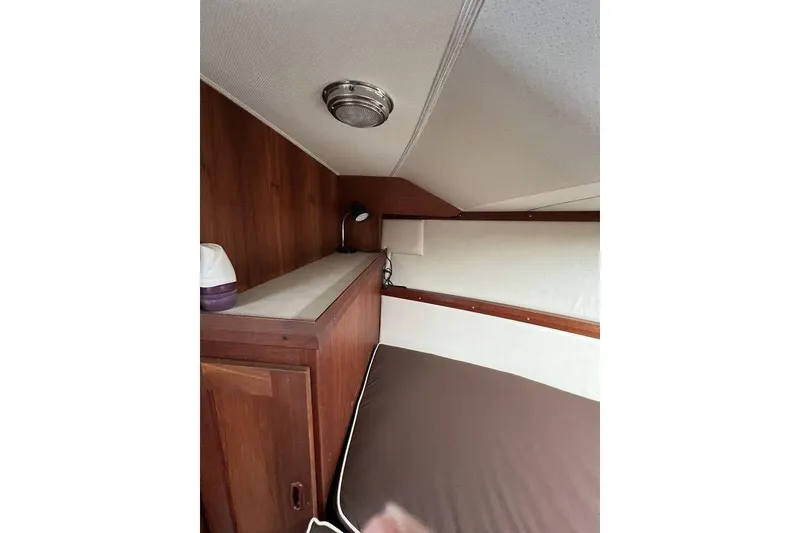 Slide: The Image of 1978 Silverton F32 cabin interior with wood paneling and cozy bed. - 24