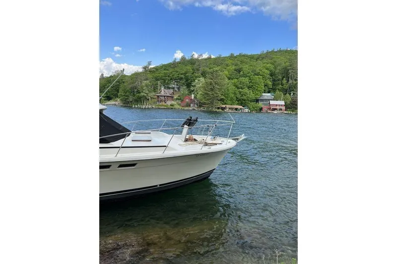 Slide: The Image of 1978 Silverton F32 boat on a scenic lake with lush green shoreline. - 27