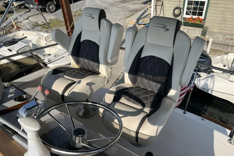 Slide: The Image of Captain's chairs on a 1978 Silverton F32 boat, featuring a steering wheel and control levers. - 5
