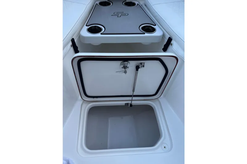 Slide: The Image of 2022 Sea Pro 219 Center Console storage compartment with cup holders and open hatch. - 13