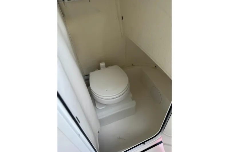 Slide: The Image of 2022 Sea Pro 219 Center Console boat interior with compact marine toilet. - 15