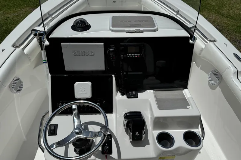 Slide: The Image of 2022 Sea Pro 219 Center Console boat dashboard with steering wheel and navigation equipment. - 17