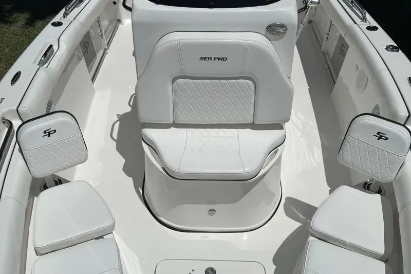 Slide: The Image of 2022 Sea Pro 219 Center Console boat interior with white seating and logo details. - 6