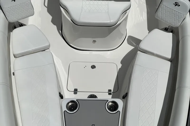 Slide: The Image of 2022 Sea Pro 219 Center Console boat interior with white cushioned seating and storage compartments. - 7
