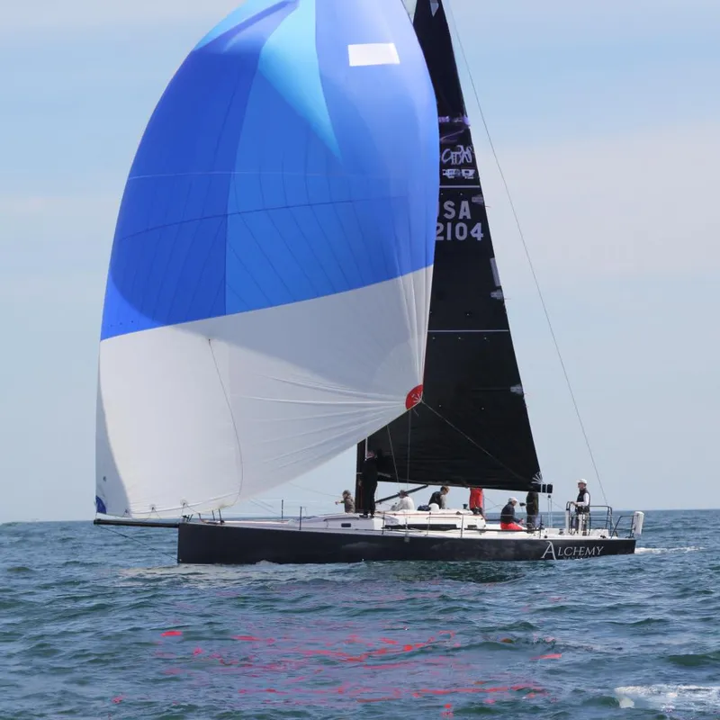 The Image of 2018 J Boats J/121 sailboat "Alchemy" with blue and white spinnaker on open water. - 0