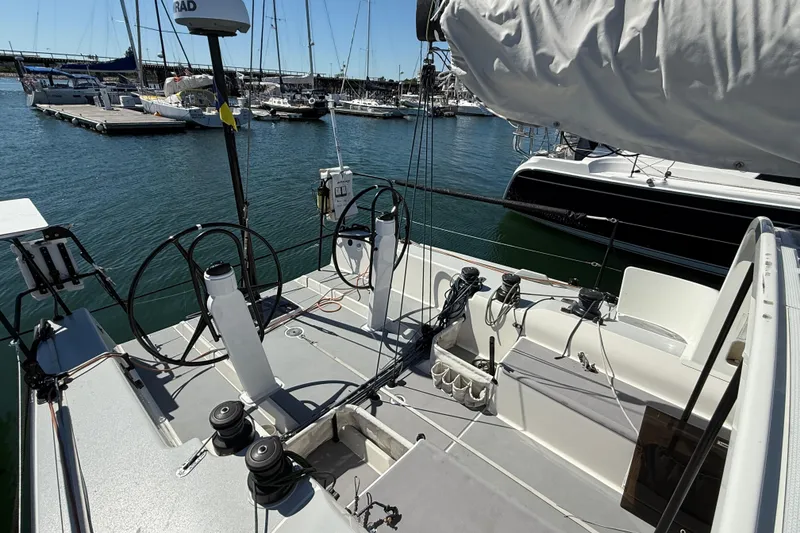 Slide: The Image of 2018 J Boats J/121 sailboat cockpit with dual steering wheels, docked in a marina. - 14
