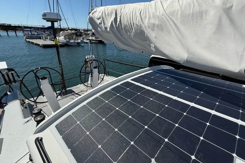 Slide: The Image of 2018 J Boats J/121 sailboat with solar panels and dual steering wheels at a marina. - 15
