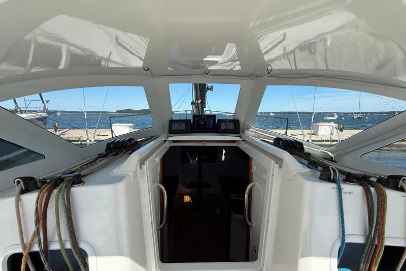 Slide: The Image of 2018 J Boats J/121 cockpit with navigation equipment, docked by the sea. - 17