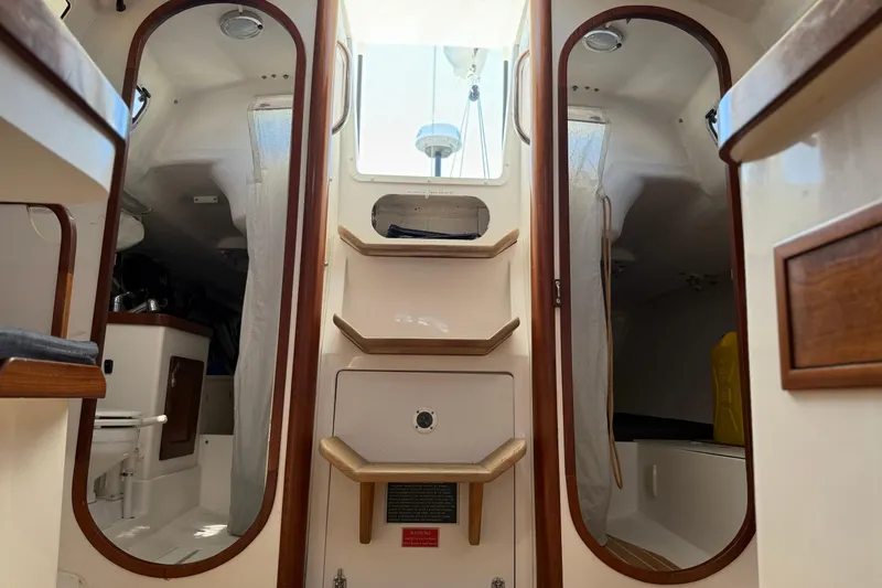 Slide: The Image of Interior of 2018 J Boats J/121 sailboat, featuring wooden accents and compact cabin layout. - 28