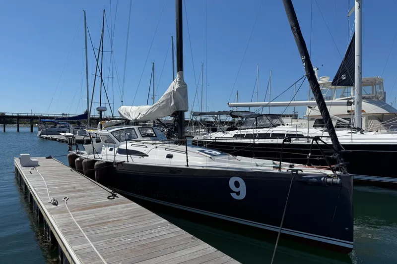 Slide: The Image of 2018 J Boats J/121 sailboat docked at marina under clear blue sky. - 7