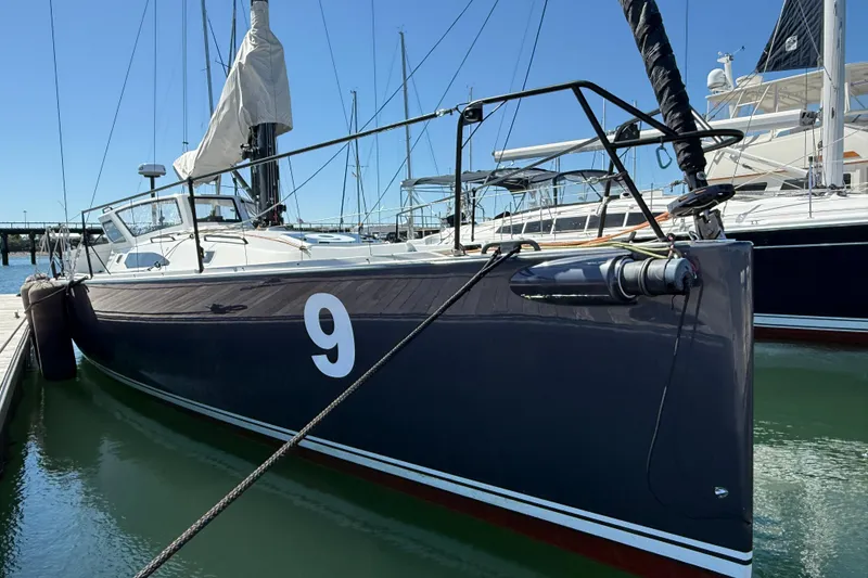 Slide: The Image of 2018 J Boats J/121 sailboat docked, featuring sleek design and number nine on hull. - 8