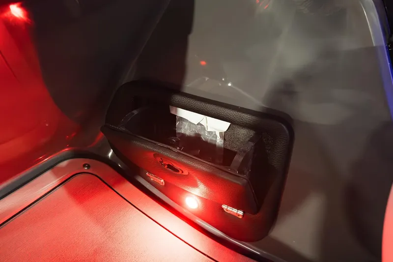 Slide: The Image of Interior storage compartment of 2026 Godfrey Monaco 255 Split Bench boat, illuminated in red light. - 24