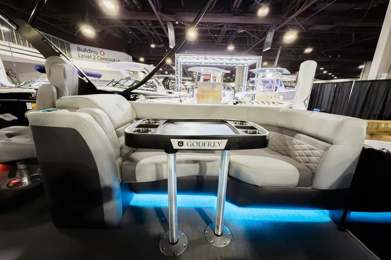 Slide: The Image of 2026 Godfrey Monaco 255 Split Bench boat interior with elegant seating and table display. - 36