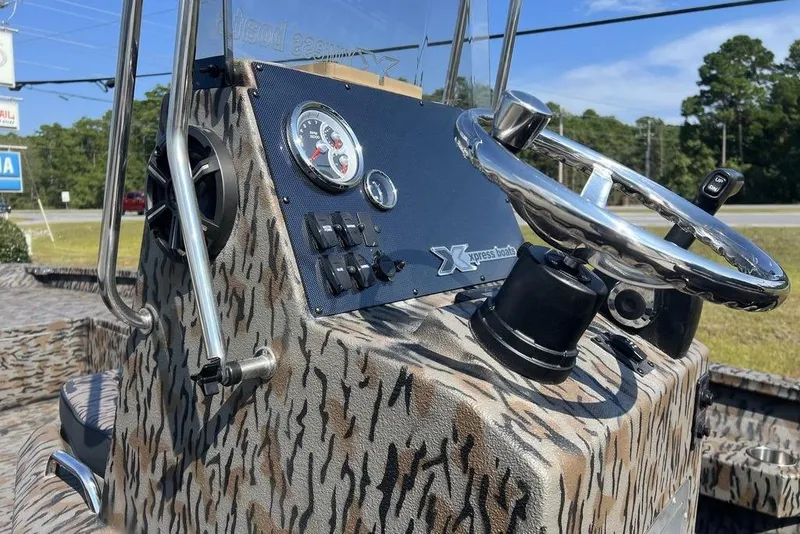 Slide: The Image of 2026 Xpress H22 boat console with camo design and chrome steering wheel. - 13