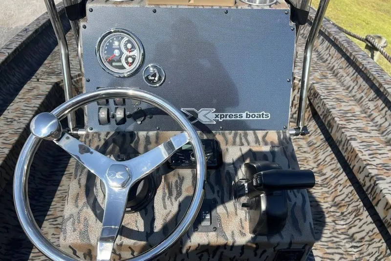 Slide: The Image of Steering console of 2026 Xpress H22 boat with camo pattern and gauges. - 14