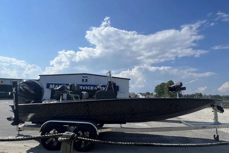 Slide: The Image of 2026 Xpress H22 boat on trailer at marine service center under blue sky. - 4