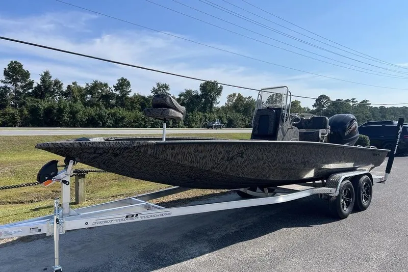 Slide: The Image of 2026 Xpress H22 boat on trailer, parked roadside under clear sky. - 5