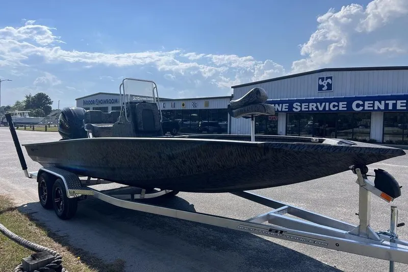 Slide: The Image of 2026 Xpress H22 boat on trailer outside marine service center. - 6