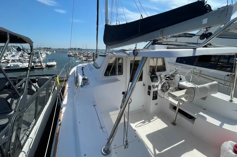 Slide: The Image of 2013 Gemini Legacy sailboat docked at marina, featuring spacious deck and steering area. - 10
