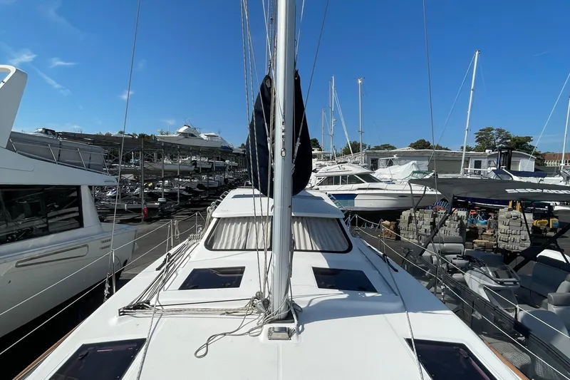 Slide: The Image of 2013 Gemini Legacy sailboat docked among other boats under clear blue sky. - 13