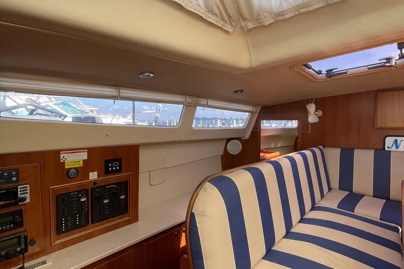 Slide: The Image of Interior of 2013 Gemini Legacy boat with striped seating and control panels. - 15