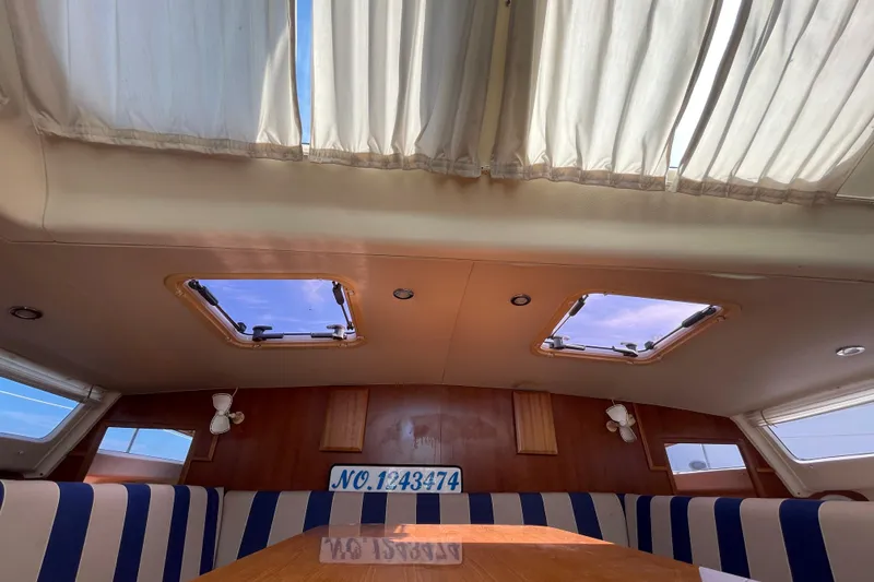 Slide: The Image of Interior of 2013 Gemini Legacy boat with striped seating and skylights. - 16