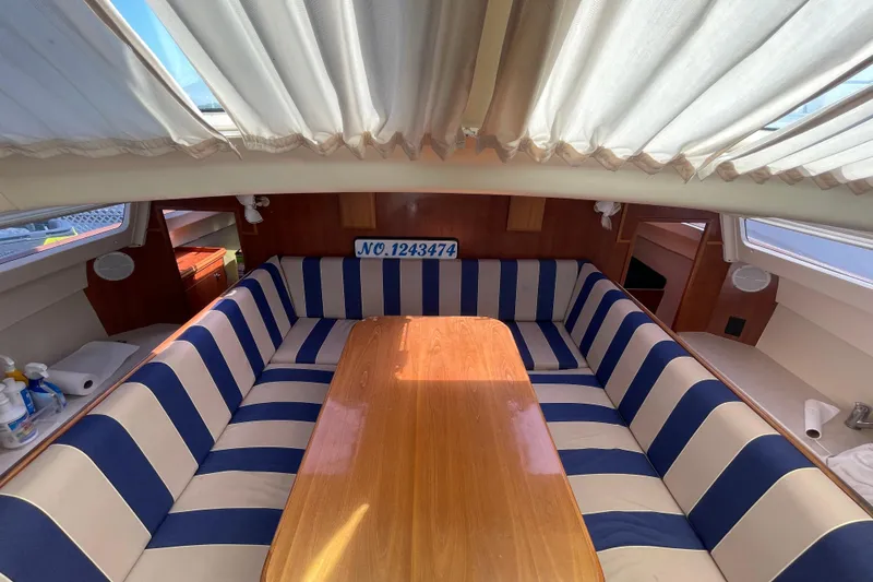 Slide: The Image of Interior of 2013 Gemini Legacy boat with striped seating and wooden table. - 17