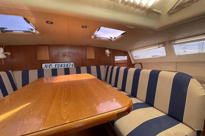 Slide: The Image of Interior of 2013 Gemini Legacy boat with striped seating and wooden table. - 18