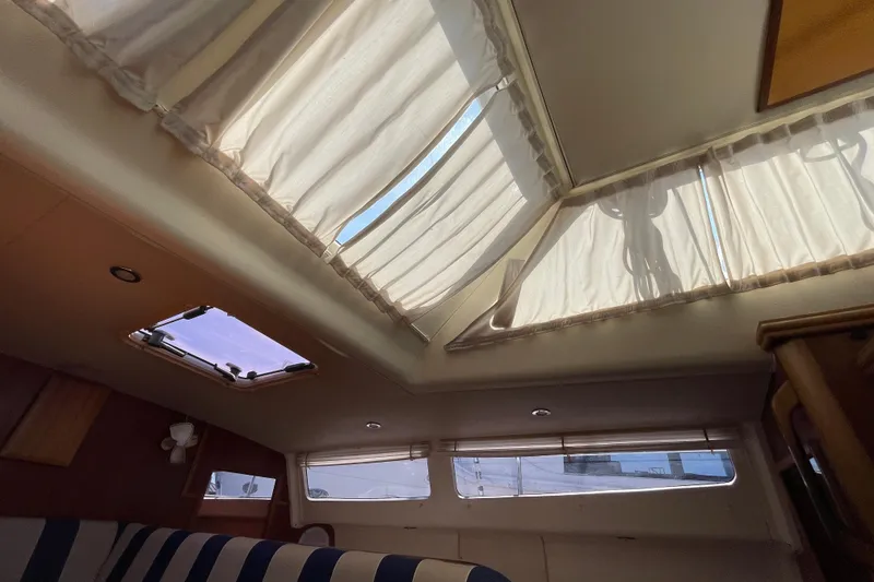 Slide: The Image of Interior view of 2013 Gemini Legacy boat with skylights and striped seating. - 19