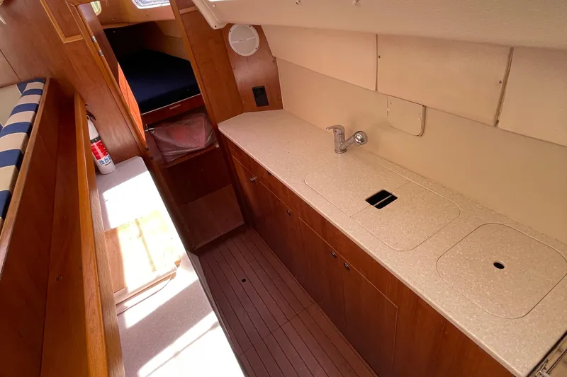 Slide: The Image of Interior of 2013 Gemini Legacy boat with wooden cabinetry and compact kitchen area. - 20