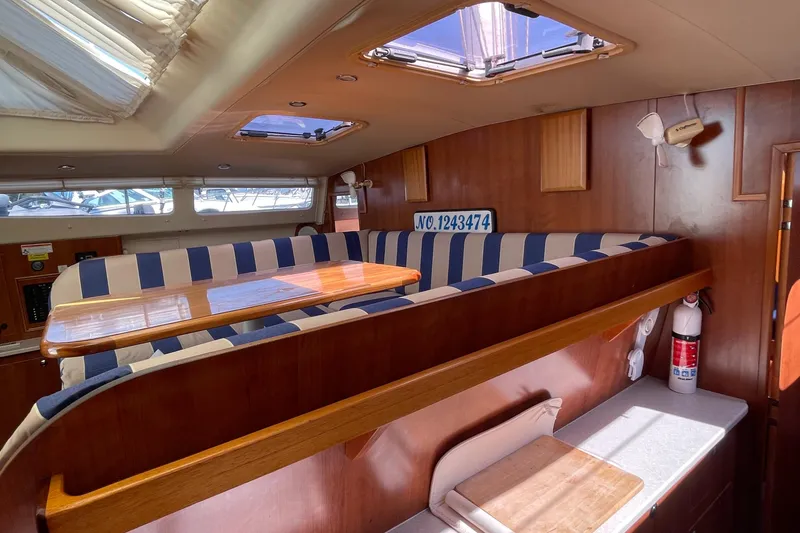 Slide: The Image of Interior of 2013 Gemini Legacy boat with striped seating and wooden table. - 21