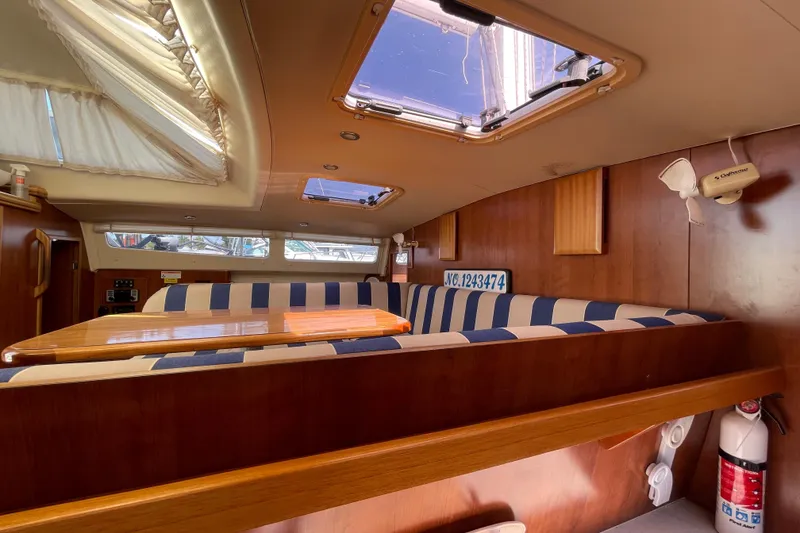 Slide: The Image of Interior of 2013 Gemini Legacy boat with striped seating and wooden table. - 22