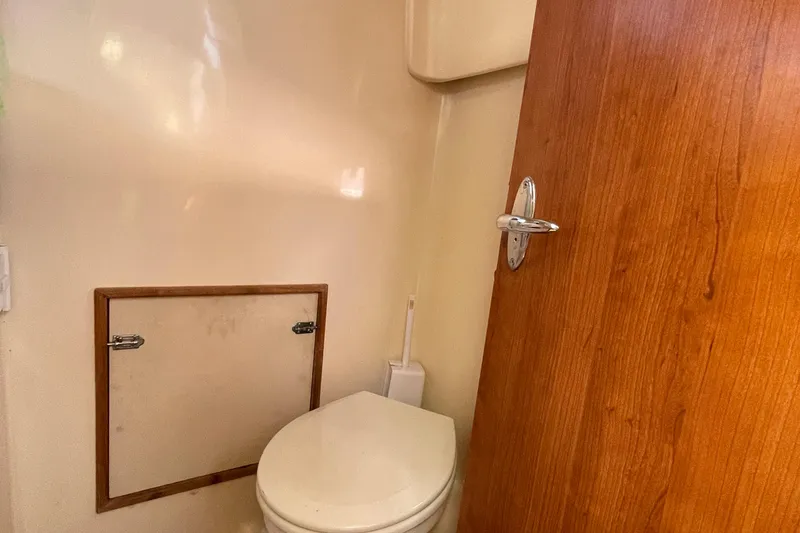 Slide: The Image of Compact bathroom in 2013 Gemini Legacy boat with wooden door and toilet. - 26