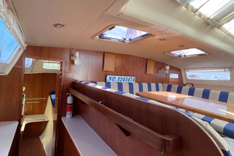 Slide: The Image of Interior of 2013 Gemini Legacy boat with striped seating and wooden finishes. - 30