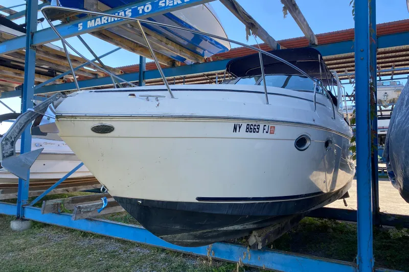 Slide: The Image of 2003 Rinker Fiesta Vee 270 boat on dry dock, front view, with visible registration number. - 3