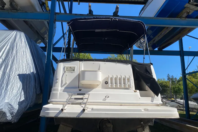 Slide: The Image of 2003 Rinker Fiesta Vee 270 boat in storage, rear view with canopy and ladder. - 4