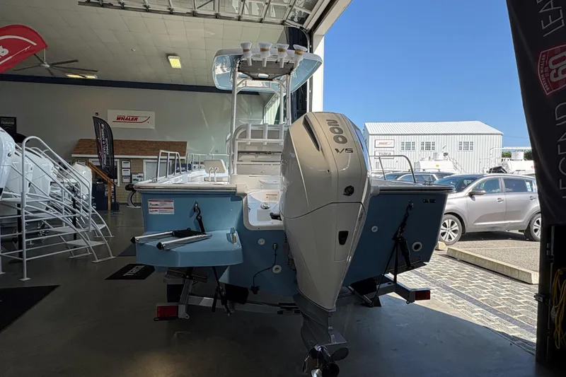 Slide: The Image of 2026 Boston Whaler 210 Montauk boat in showroom, featuring powerful 200 V6 engine. - 1