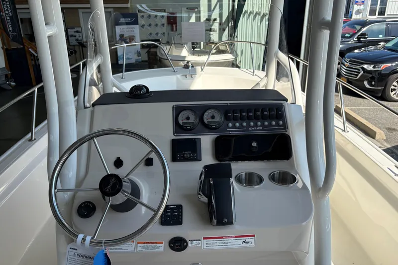 Slide: The Image of 2026 Boston Whaler 210 Montauk boat dashboard with steering wheel and controls. - 12