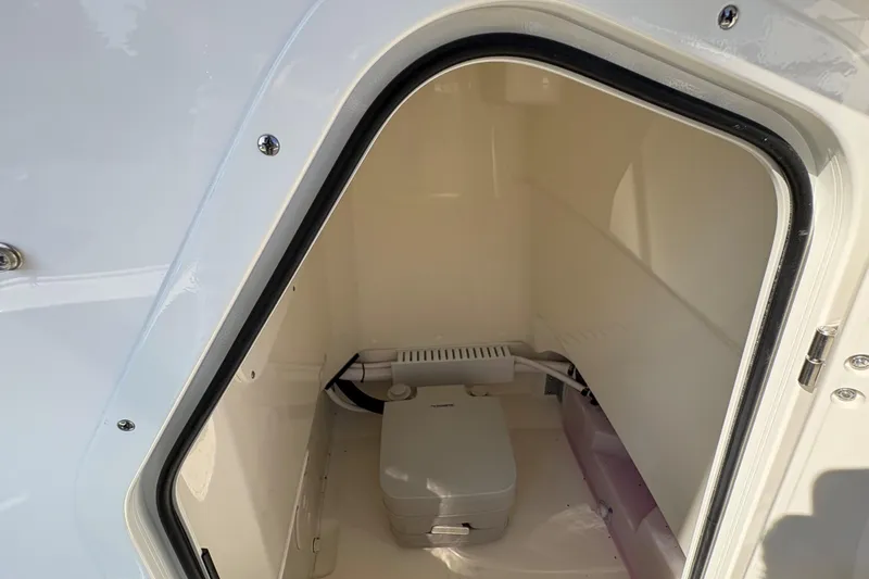 Slide: The Image of 2026 Boston Whaler 210 Montauk storage compartment with portable toilet. - 13