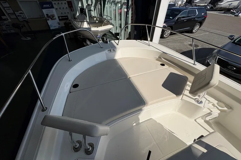 Slide: The Image of 2026 Boston Whaler 210 Montauk boat interior with cushioned seating and stainless steel railings. - 15
